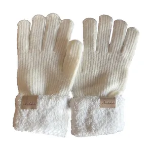 Thick white knitted gloves with plush faux fur cuffs and decorative leather label