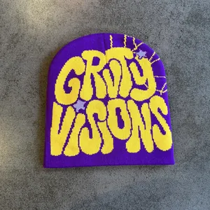 Dettaglio del berretto in maglia viola con scritta gialla Groovy Visions e texture morbida