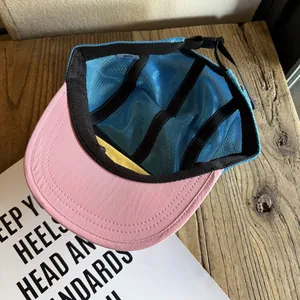 Detail of five-panel camp cap showing mesh body, pink brim and adjustable rear buckle