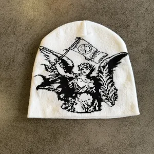 Detailopname van witte gebreide muts met zwart engel jacquard patroon en zachte stof