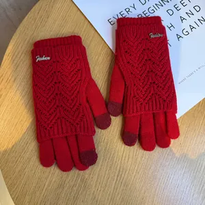Dettaglio di guanti in maglia rossi con motivo a cuore e punte touch screen