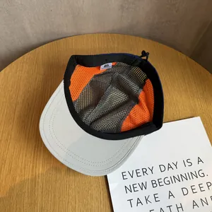 Macro view of breathable mesh lining and adjustable drawstring on flat brim five-panel cap