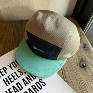 Detail of color-block five-panel mesh cap with khaki breathable fabric and flat mint brim
