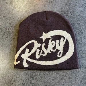 Close-up of Risky letter jacquard knit texture on dark brown warm winter beanie hat