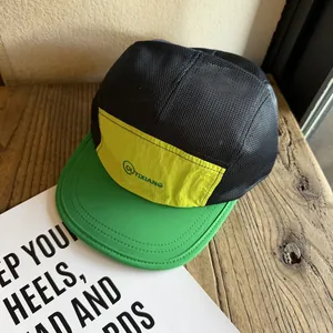 Detail of breathable black mesh and yellow panel on a color-block camper cap