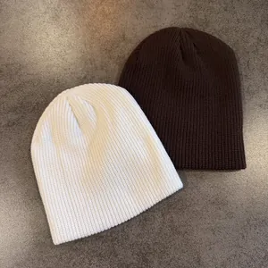 Close-up of thick ribbed knit texture on cream and brown winter beanies for street style