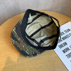 Detail view of cotton camo baseball cap interior with adjustable strap and brand label