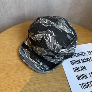 Detail of 5-panel camp cap featuring grey tiger stripe camo and ripstop fabric texture