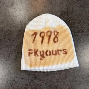 Detail view of the 1998 printed graphic on this beige street style knit beanie hat