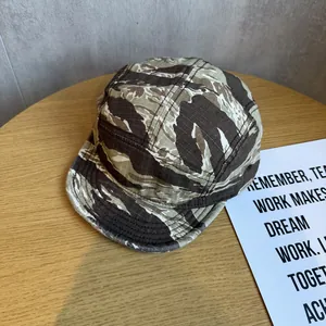 Close-up of tiger stripe camo pattern on a five-panel cotton twill flat brim hat