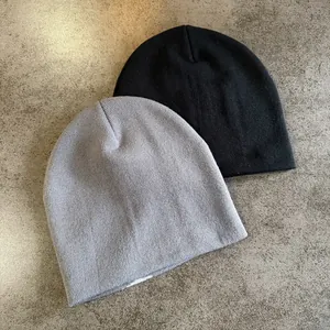 Close-up of fine knit texture on grey and black minimalist beanie hats for winter