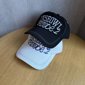 Classic embroidered baseball caps in black and white cotton on a wooden table surface