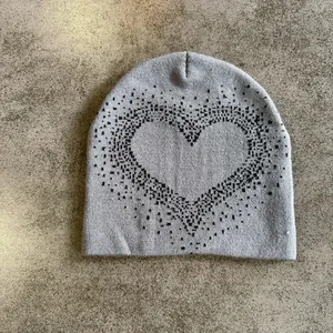 Close-up of grey knitted beanie with heart pattern showing detailed fabric texture