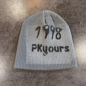 Detailed close-up of grey knit beanie with 1998 FKyours graffiti print and texture