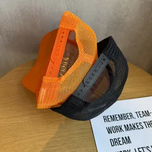 Modern mesh trucker hats with star pattern in orange and black on wooden background