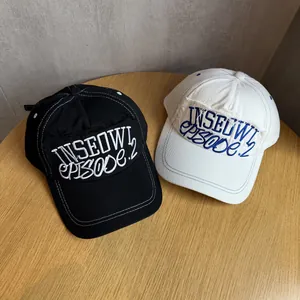 Close-up of cotton baseball caps with letter embroidery and distressed frayed edge detail