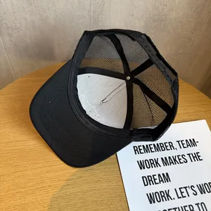 Detail view of the breathable black mesh net and adjustable plastic snap closure of the cap