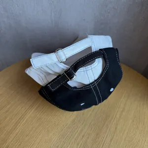Adjustable cotton baseball caps in black and white with contrast stitching and metal buckle
