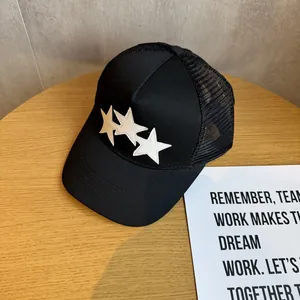 Detail of black trucker hat with white leather stars and breathable mesh back