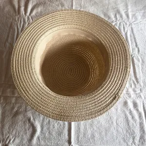 Flacher Strohhut in hellem Beige mit dichtem Geflecht und innerem Schweißband