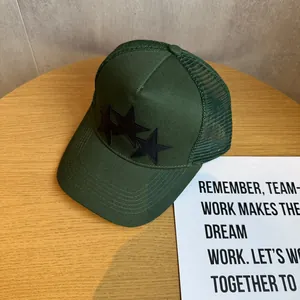 Close-up of deep green trucker hat featuring breathable mesh and black star embroidery