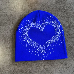 Macro detail of royal blue knit beanie featuring a white heart pattern and soft texture