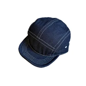 Dark blue denim 5-panel hat with white contrast stitching and metal eyelets for ventilation