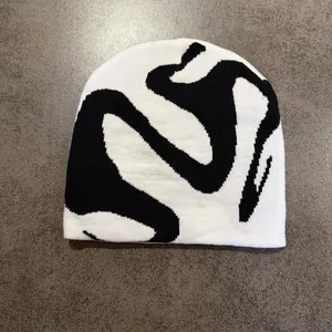 Close-up of black and white jacquard knit beanie with abstract street style pattern
