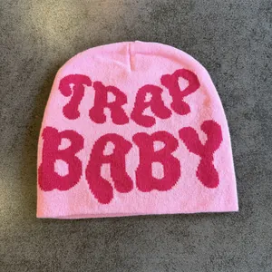 Detailed close-up of pink knitted beanie featuring Trap Baby jacquard pattern texture