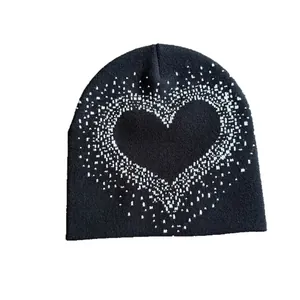 Black knitted beanie hat with a white textured heart pattern for winter warmth