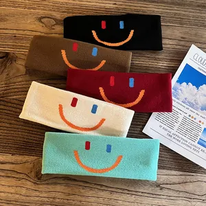 Gros plan de bandeaux de sport tricotés colorés avec motif smiley sur bois rétro