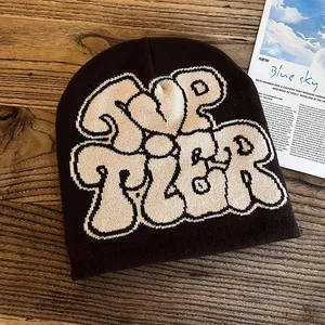 Detailed knit pattern on dark brown beanie featuring ivory TOP TIER letter design