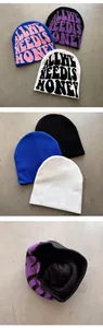 Detail view of jacquard knit beanies showing front lettering, back and interior texture