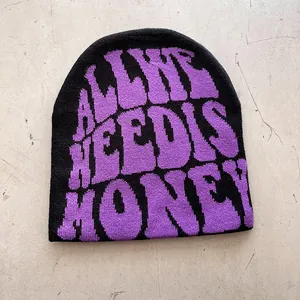 Detail of black knitted beanie featuring purple jacquard text on textured background