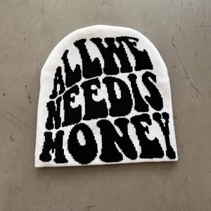 Detail of white knit beanie with black jacquard lettering and soft texture finish