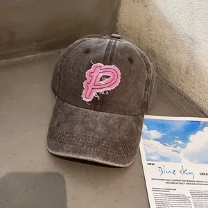 Makro-Detail der Vintage-Baseballkappe mit pinkem P-Stickpatch und Fransendetails