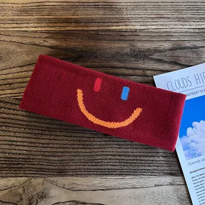 Détail du bandeau de sport bordeaux tricoté avec motif smiley brodé en couleur