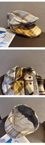 Detailed close-up of retro plaid ivy hats featuring wool texture and metal button accents