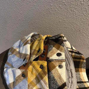 Detailed view of plaid wool hats with premium leather patch and metal snap closure