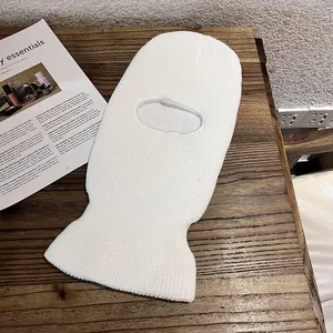 Detail of soft white knitted balaclava with warm thick texture on wooden surface