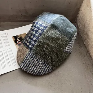 Gros plan d'une casquette plate patchwork montrant des textures de tweed et pied-de-poule