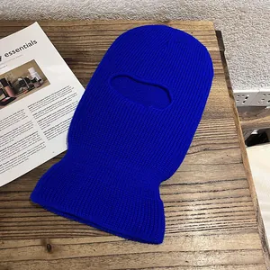 Detail of blue knitted balaclava with warm thick texture on wooden surface