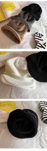 Détail de bonnets en tricot avec broderie Studios en plusieurs couleurs d'automne