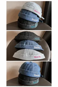 Dettaglio del cappello docker in denim lavato con ricamo Magic Club e cinturino regolabile