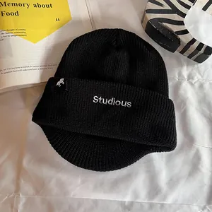 Détail de la broderie Studious et étiquette cheval sur le bonnet en tricot noir
