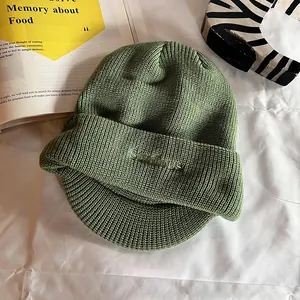 Détail du bonnet en tricot vert avocat avec broderie 'Studious' et texture côtelée