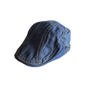 Retro dark blue denim newsboy cap with orange contrast stitching on white background