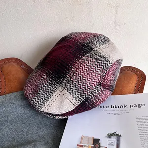 Detail of red and black herringbone tweed plaid ivy cap with retro British style texture