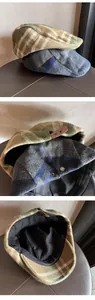 Close-up of adjustable leather strap with metal buckle on plaid newsboy cap