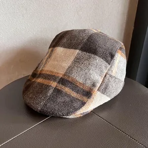 Close-up of vintage brown plaid flat cap featuring thick wool texture and classic patterns